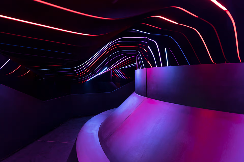 Timeworm: a photo of an art installation, a dark room with large bars of animated light. Photo Credit: ?